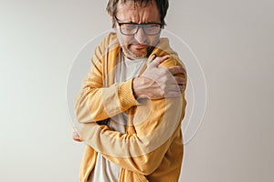 Aching frozen shoulder pain as symptom of rotator cuff tendinitis, adult caucasian male in pain photo