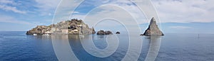 Aci Trezza panoramic view of cyclopean coastline, famous rocks and island in blue sea and sky of Sicily