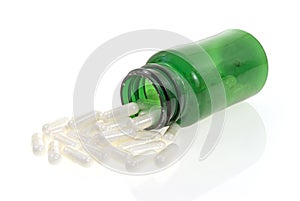 Acidophilus spilling from opened green bottle photo