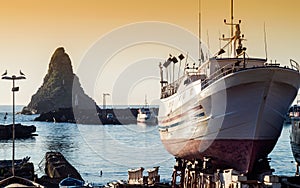 Acitrezza harbor with old boat