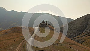 ack car driving towards tourist attraction - Gergeti trinity monastery on hill. Travel in KAzbegi concept