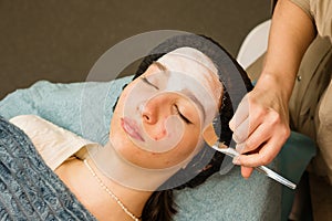 Acne treatment at doctor. Applying facial mask