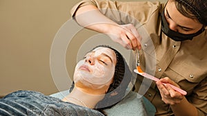 Acne treatment at doctor. Applying facial mask