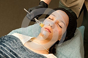 Acne treatment at doctor. Applying facial mask