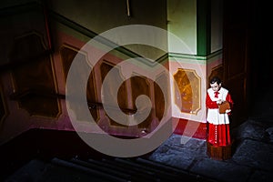 Acolyte with collecting box for gifts in church