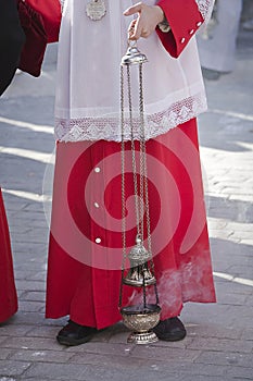 Acolyte supports censer in a procession of Holy Week