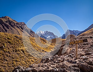 Aconcagua south wall view and danger sign from Aconcagua Provincial Park in Cordillera de Los Andes - Mendoza Province, Argentina