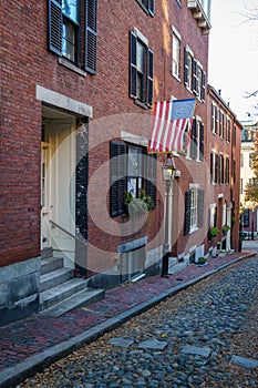 Acorn Street Beacon Hill house during fall harvest with American Flag and cobblestone alley in Boston, Massachusetts