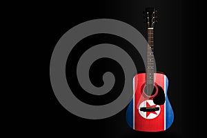 Acoustic concert guitar with a drawn flag North Korea, on a dark background, as a symbol of national creativity or folk song