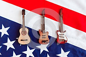 Acoustic, electric and bass guitar on American flag background. Minimal concept, top view.