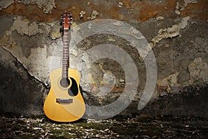 Acoustic guitar against grungy wall photo