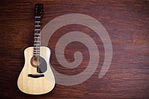 Acoustic guitar against an old wooden background.