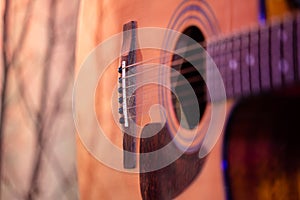 Acoustic guitar on a beautiful colored background. The concept of stringed instruments