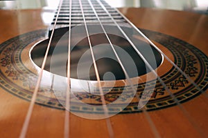 Acoustic guitar Classic acoustic guitar at weird and unusual perspective closeup. Six strings free frets sound hole and soundboard photo