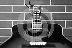 Acoustic guitar closeup over brick wall background