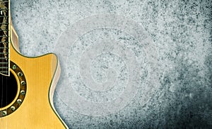 Acoustic guitar on a gray texture.