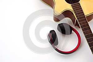 Acoustic guitar and the headphones are placed on the side. Concept of love, leisure and music