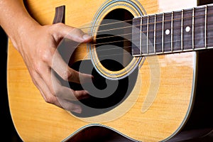 Acoustic guitar man`s hand strumming guitar chords close up photo