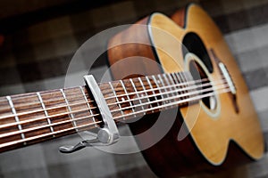 Acoustic guitar neck with a capo