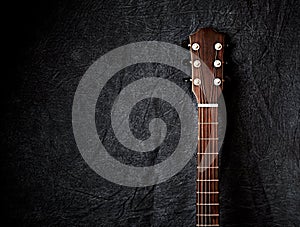 An Acoustic Guitar Neck on dark Cloth Background