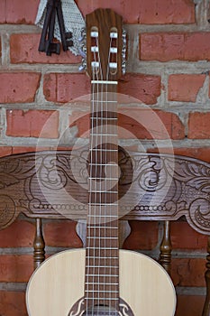 Acoustic guitar on an old armchair vertical