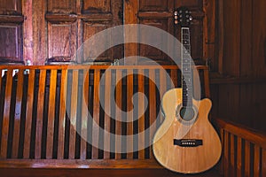 Acoustic guitar placed on wooden floors.
