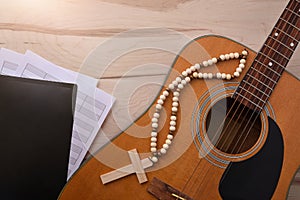 Acoustic guitar with religious songbook on wooden table top view photo