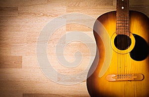 Acoustic guitar resting against a blank grunge background