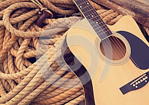 Acoustic guitar on a rough rope beige background