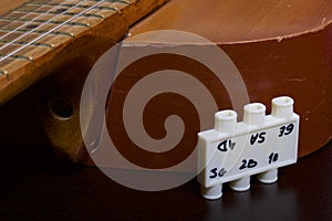 Acoustic guitar and tuning fork to adjust it. On a dark background.