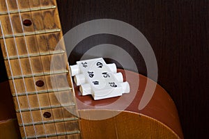 Acoustic guitar and tuning fork to adjust it. On a dark background.