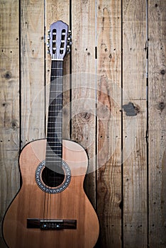 Acoustic guitar on vintage style wood background. Copy space with musical guitar instrument