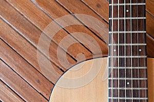 Acoustic guitar on a wooden background with copy space.The guitar is a fretted musical instrument that usually has six strings