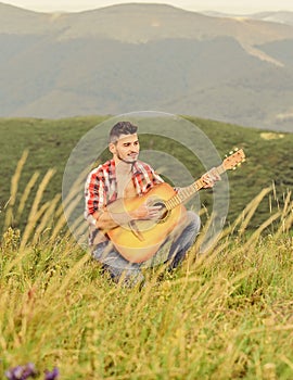 Acoustic music. Man with guitar on top of mountain. Summer music festival outdoors. Playing music. Sound of freedom