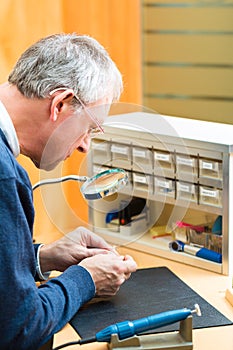 Acoustician working on a hearing aid