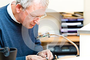 Acoustician working on a hearing aid photo