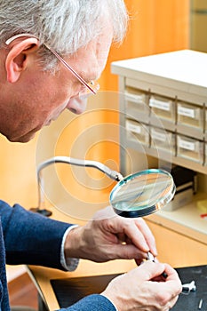 Acoustician working on a hearing aid photo