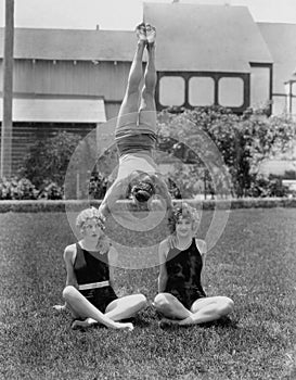 Acrobat balancing on womens shoulders