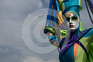 Acrobat in colorful mask in the blue sky
