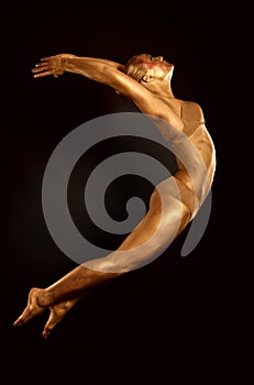 Acrobat dancer toned in gold jumping