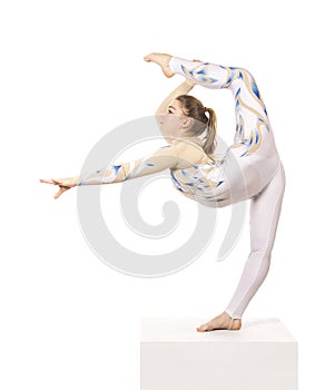 Acrobat doing gymnastics, a young circus artist in a white and blue suit, performs acrobatic elements