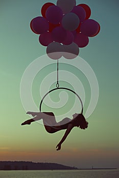 Acrobat girl lying on acrobatic circle.
