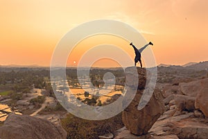 An Acrobat performs a hand stand at the spectacular sunset point at Hampi in Karnataka, India