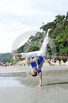 Acrobatic action of capoeira instructor on the beach
