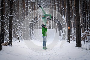 Acrobatic duo making nice pose in the snowy forest during the winter. Concept relationship, happiness and trust