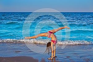 Acrobatic gymnastics bikini girl in a beach