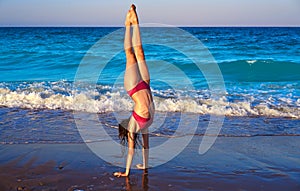 Acrobatic gymnastics bikini girl in a beach photo