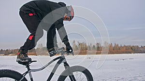 Acrobatic trick. Stand in bicycle seat while bike is in ride. Professional extreme sportsman biker stand fat bike in