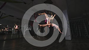 Acrobatic women doing tricks on aerial hoop