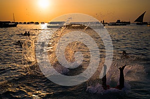 Acrobats jumping into the water in Zanzibar photo